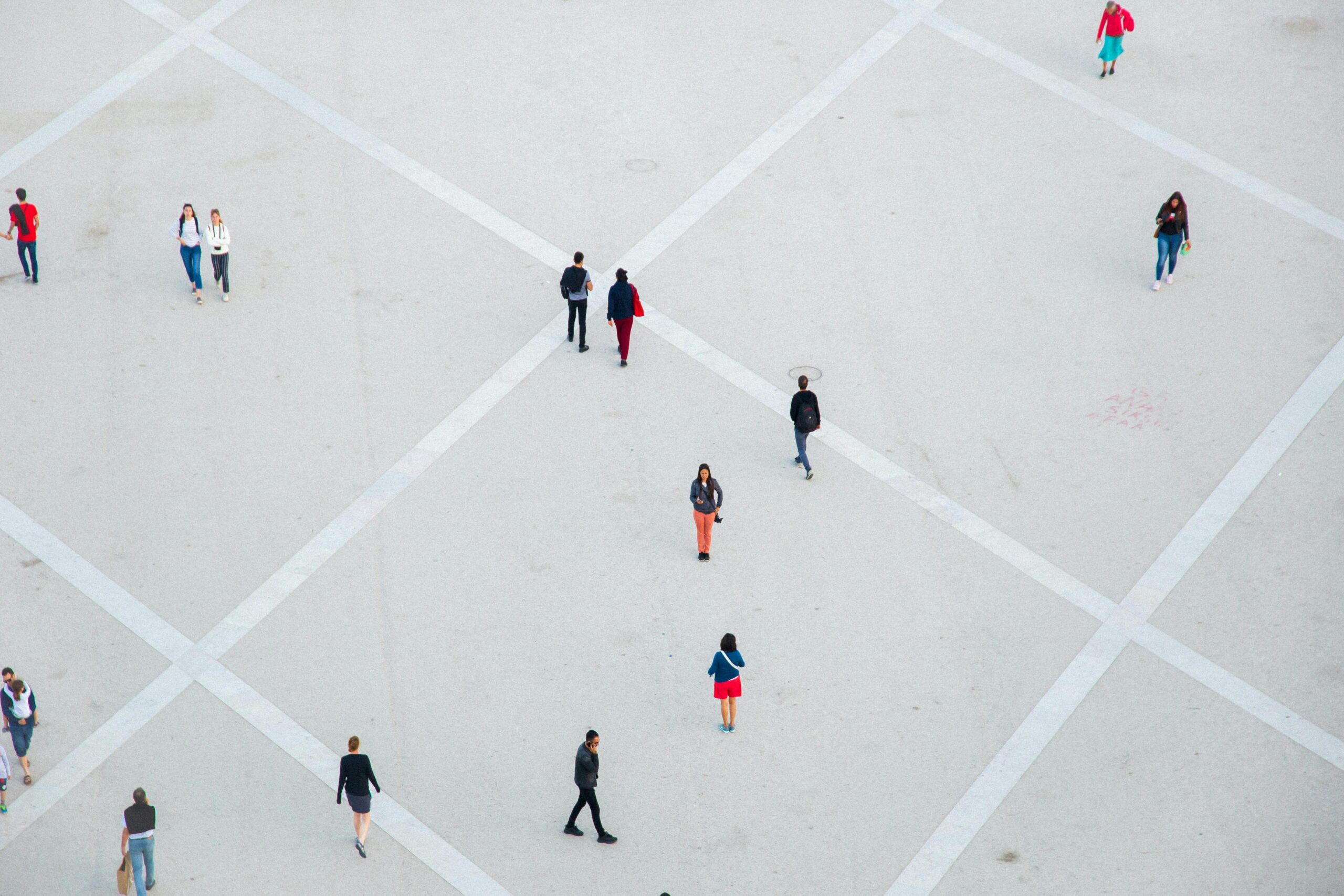 Aerial photo people walking in a public square, indicating the importance of a person tracing check's ability to locate someone in a distributed world
